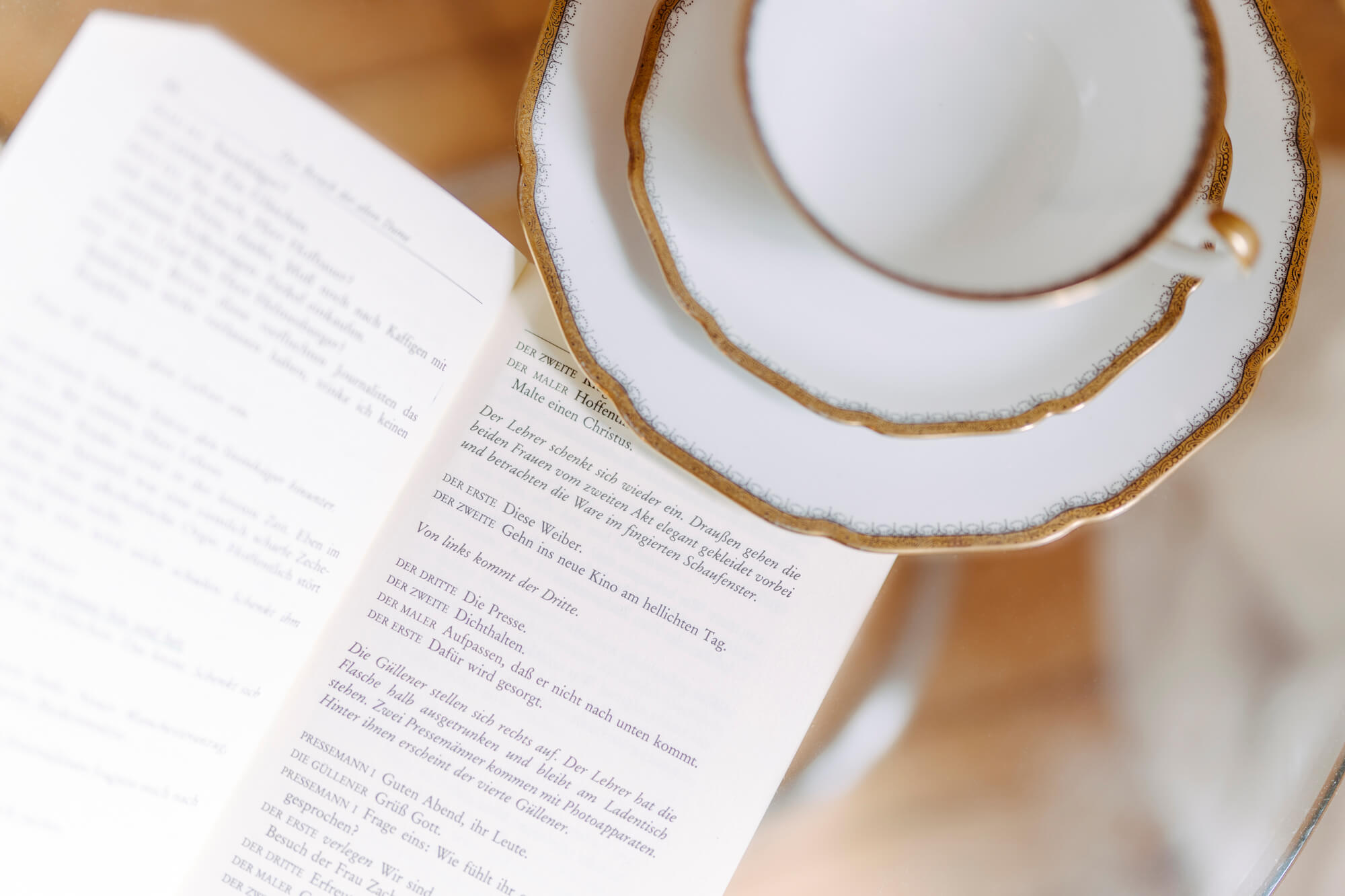 Lisa Treusch Fotografin Fotografie Mainz Detailaufnahme eines Buches und eine weißen Teetasse verziert mit Goldrändern