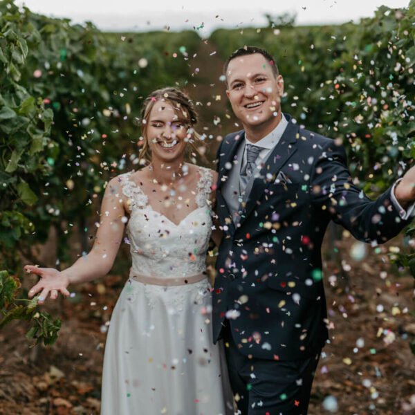 Lisa Treusch Hochzeitsfotografin Fotoshooting draußen Brautpaar in den Weinbergen wirft Konfetti witzige Hochzeitsbilder